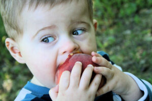 little kid eating a peach