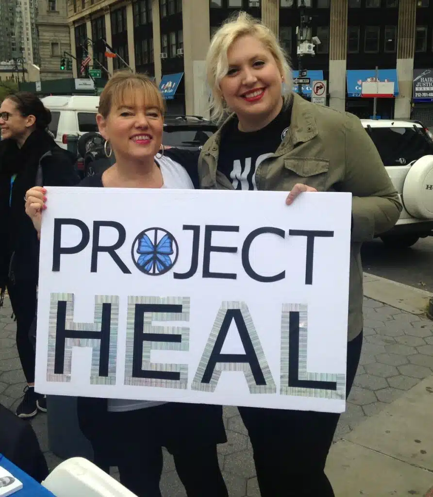 people holding a project heal sign
