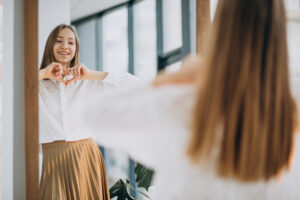 young woman looking happily into mirror