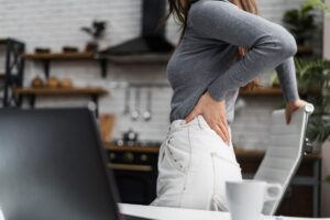 woman with osteoporosis from eating disorder holding her back in pain