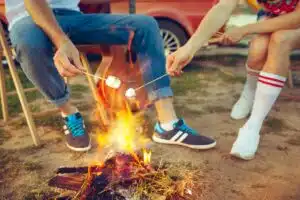 teens at summer camp toasting marshmallows