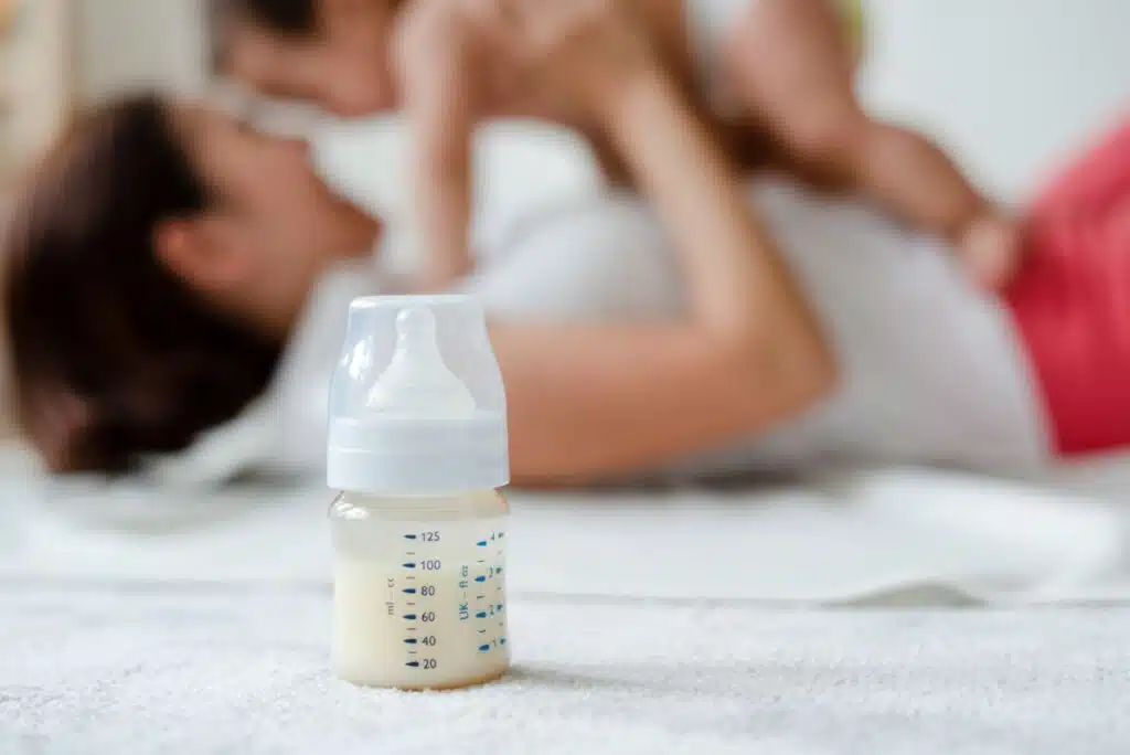 baby formula with mom and baby in background
