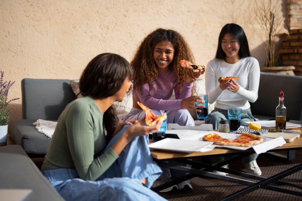 women eating pizza together