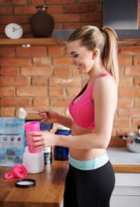 woman preparing for exercise with supplements