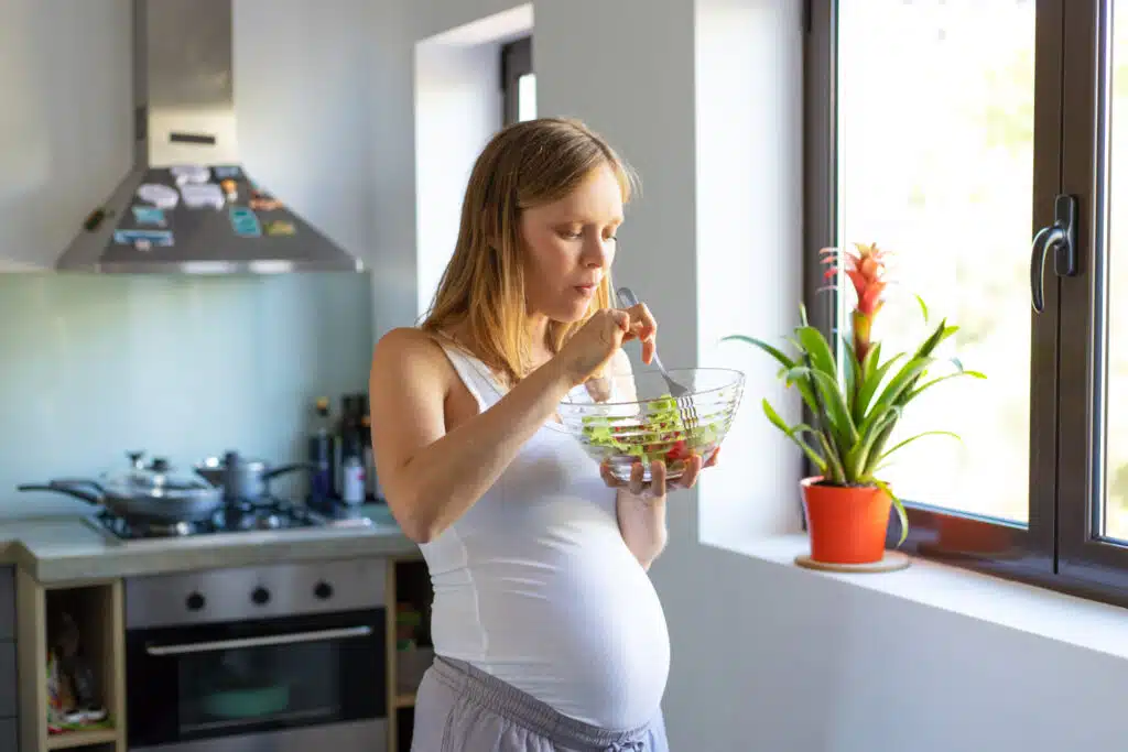 pregnant woman eating lunch of small salad