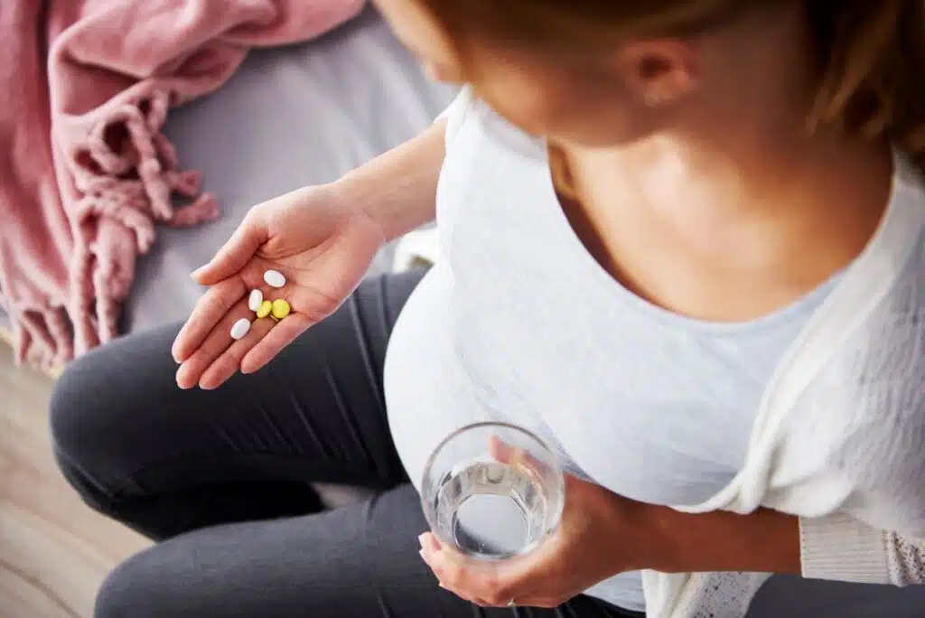 pregnant woman taking vitamins and supplements