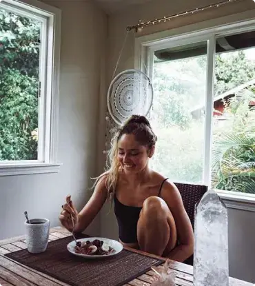 happy woman eating breakfast after eating disorder recovery