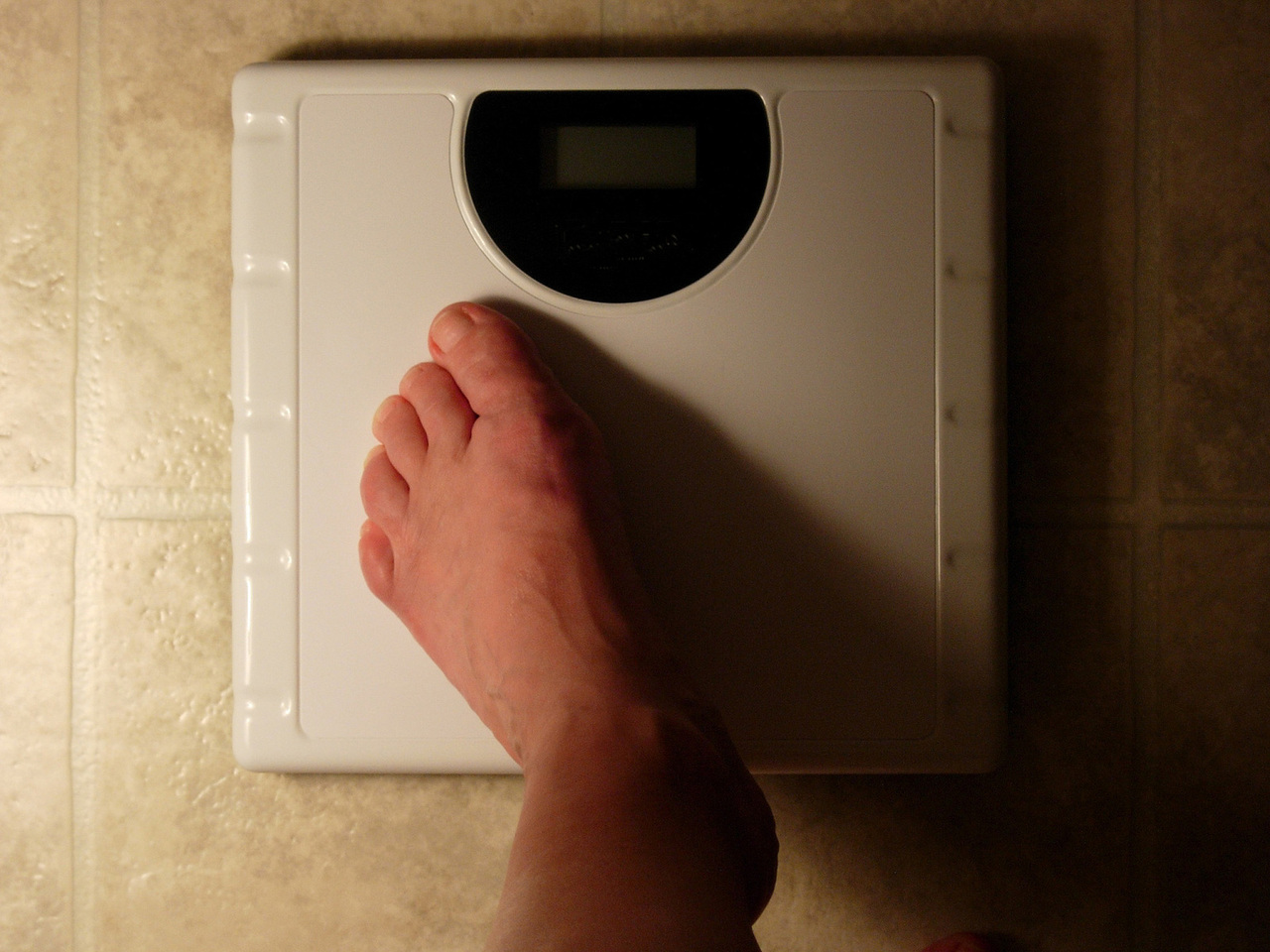 person with eating disorder stepping on scale
