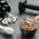 scoops of protein poweder, pre-workout, and creatine